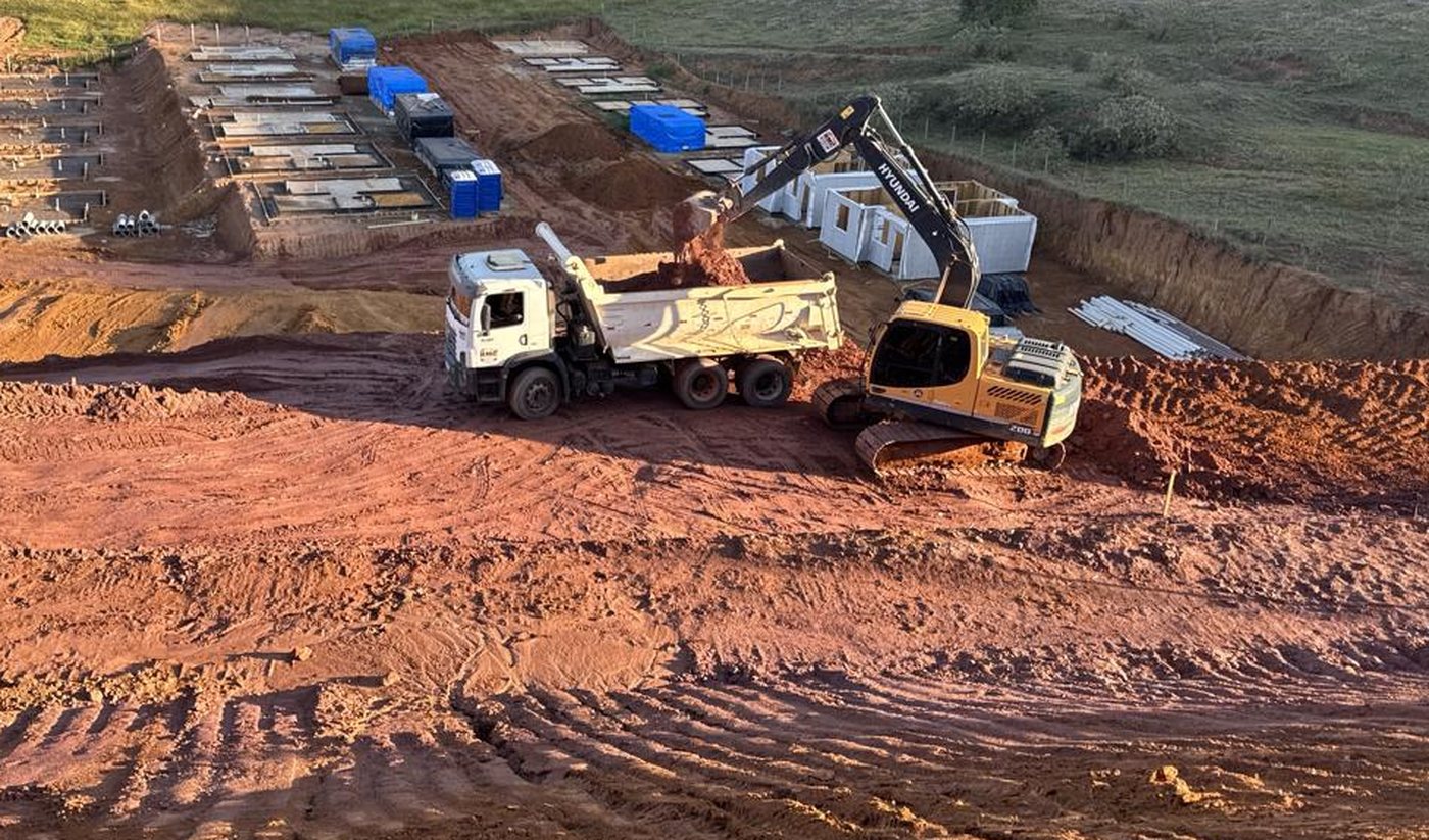 Escavadeira e caminhão em terraplenagem